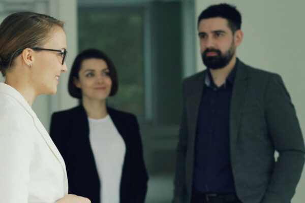 Trzy osoby podczas spotkania biznesowego w biurze, grafika promująca projekt